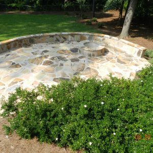 firepit and stone wall in backyard