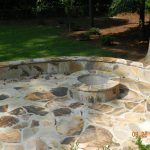 firepit and stone wall in backyard