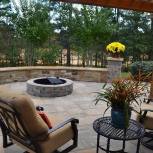 firepit with stone wall and flowers