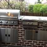 outdoor grill with red brick wall