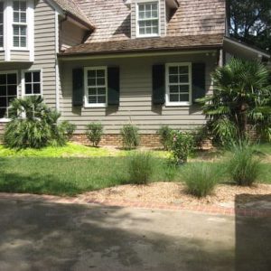 flowers and green grass in front of house