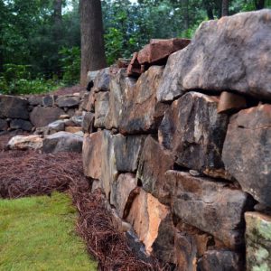 stone wall and pinestraw