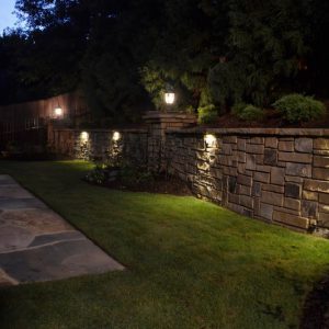 stone wall with grass and outdoor lighting