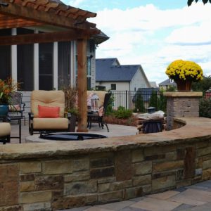 firepit with stone wall and flowers